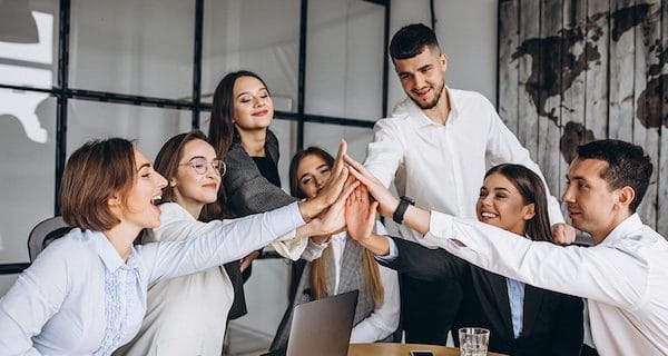 team giving high five in a workspace